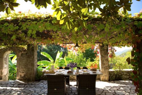 a table under a pergola with a table and chairs at Villagio Magnolia in Sívros