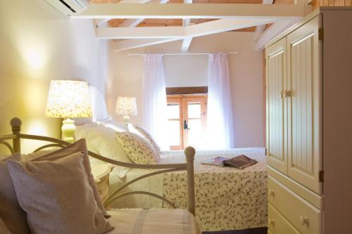a room with a bed and a chair and a window at Villagio Magnolia in Sívros