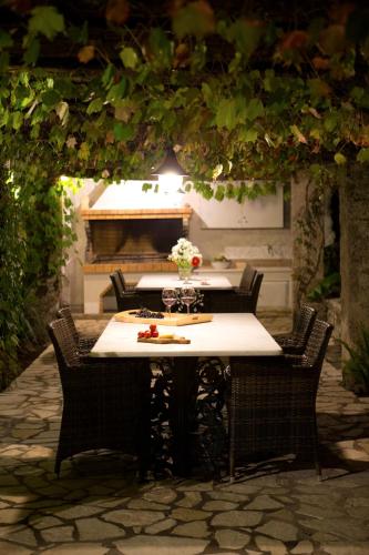 a table with four chairs and a table with flowers on it at Villagio Magnolia in Sívros