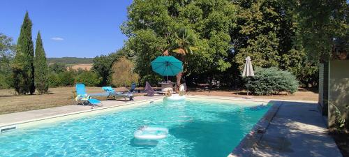 a swimming pool with two people playing in the water at Domaine les Garrigues in Puygaillard-de-Quercy