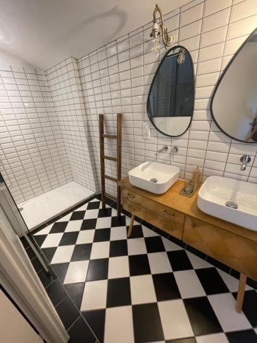 ein Badezimmer mit zwei Waschbecken, einem Spiegel und einer Badewanne in der Unterkunft Maison piscine Lot in Laburgade