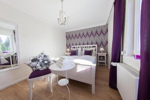 a bedroom with a white bed and a desk and a chair at Ferienhaus Margret in Winterberg