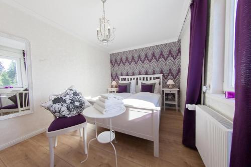 1 dormitorio con cama blanca, escritorio y silla en Ferienhaus Margret, en Winterberg