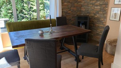 a wooden table and chairs in a room with a fireplace at Chalet Heide in Winterberg