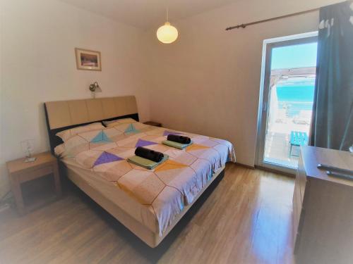 a bedroom with a bed and a large window at Seaside apartments Brist in Tkon