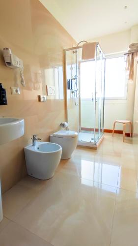a bathroom with two sinks and a glass shower at Catania Sea Palace Hotel in Catania