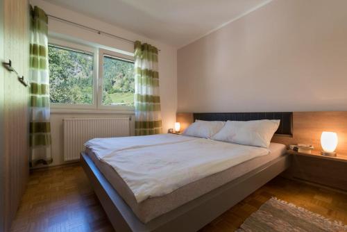 um quarto com uma cama grande e 2 janelas em Ela Apartments - 1 em Kranjska Gora