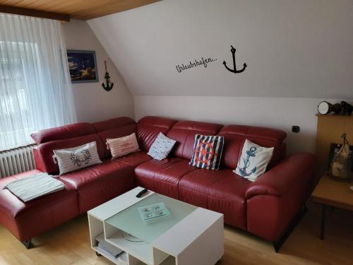a living room with a red couch and a table at Am Kanal in Neuhaus an der Oste