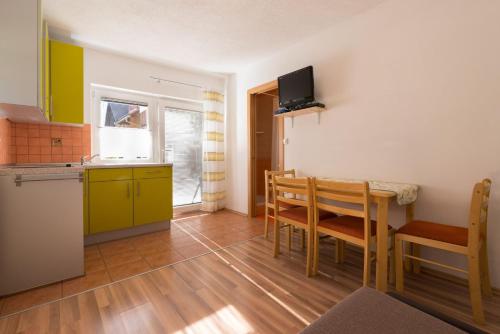 cocina y comedor con mesa y sillas en Ela Apartments - 2, en Dovje