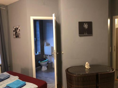 a room with a bathroom with a toilet and a table at Flensburg City - 24h in Flensburg