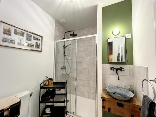 a bathroom with a sink and a glass shower at Studio LA RECYCLERIE - Maison 1911 - confort & prestige in Gien