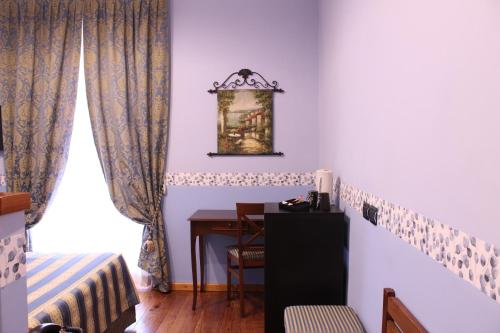 a room with a desk and a table and a window at Hotel Belle Epoque in Sanremo
