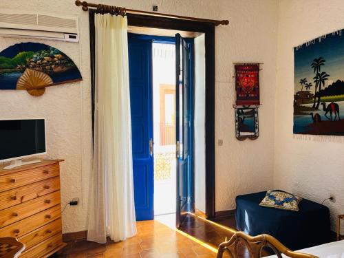 a bedroom with a blue door leading to a bedroom at Perla Salina in Leni