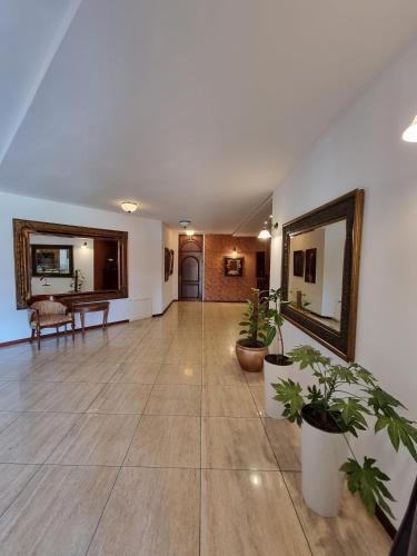 a large hallway with potted plants and a mirror at Hotel Górski in Wolbórz
