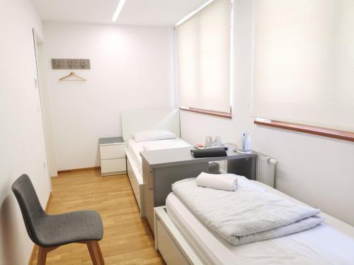 a room with two beds and a desk and a chair at Rooms Sincere 1830 in Ljubljana