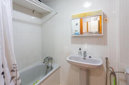 a white bathroom with a sink and a bath tub at Mtsrat8 in Torrevieja