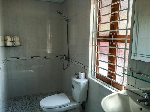 baño con aseo y lavabo y ventana en B & B Accommodation Service, en Hoi An