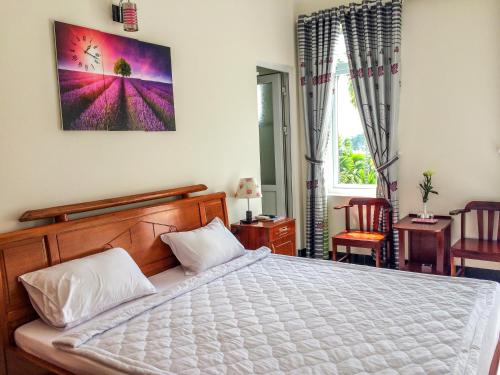 a bedroom with a large bed and a window at B & B Accommodation Service in Hoi An