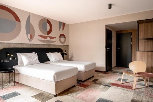 a bedroom with two beds and a table and a chair at Forest Hotel in Kraków