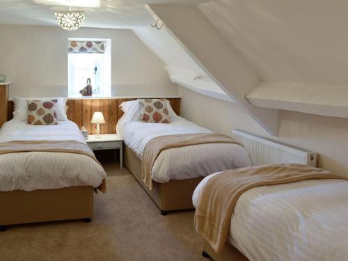 a attic room with two beds and a desk at The Farmhouse in Holwell