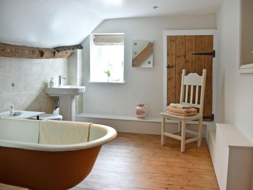 a bathroom with a bath tub and a sink at The Farmhouse in Holwell