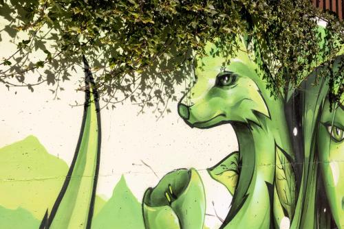 a painting of a green dinosaur on a wall at Pension Gulla - Ferienhaus Appartements B&B in Neustift im Stubaital