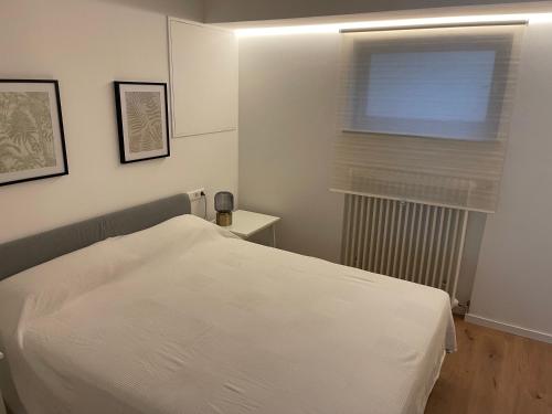 ein Schlafzimmer mit einem weißen Bett und einem Fenster in der Unterkunft Schöne Wohnung direkt am Naturpark in Leinfelden-Echterdingen