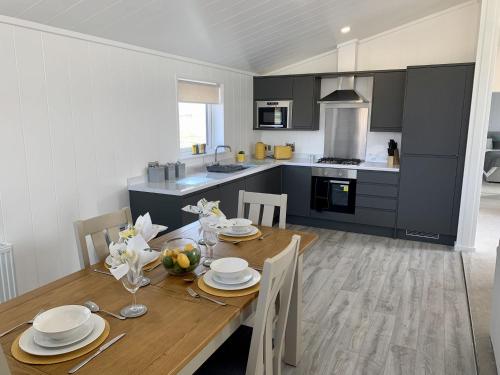 a kitchen with a wooden table and a dining room at Cherry Blossom 43 Hot Tub in Garton