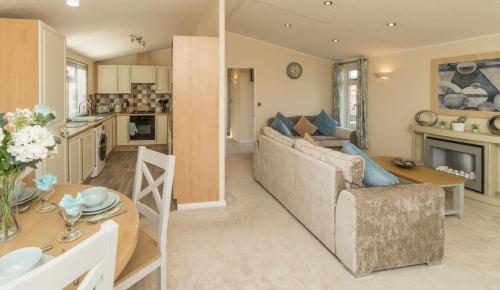 a living room and kitchen with a couch and a table at Birch 24 Hot Tub in Garton