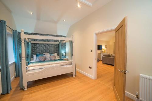 sypialnia z łóżkiem z niebieskim baldachimem w obiekcie Maple 20 Hot Tub w mieście Garton