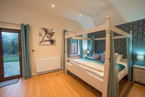 1 dormitorio con cama con dosel y ventana en Maple 20 Hot Tub, en Garton