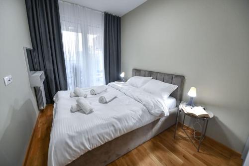 a bedroom with a white bed with towels on it at Petar's aparment luxury new in Skopje