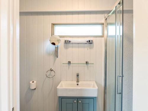 a bathroom with a sink and a shower at Fig Tree Shepherds Hut in Bridport
