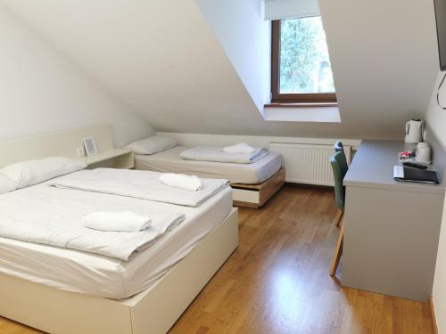 two beds in a small room with a window at Rooms Sincere 1830 in Ljubljana