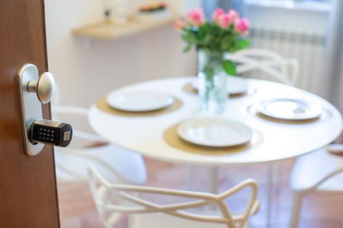 a table with plates and a vase of flowers on it at Dimora del Sole - Intero Appartamento in LʼAquila