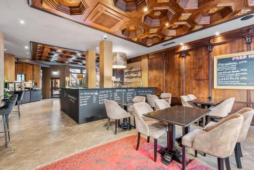 a restaurant with tables and chairs and a chalkboard at KING's Hotel First in Munich