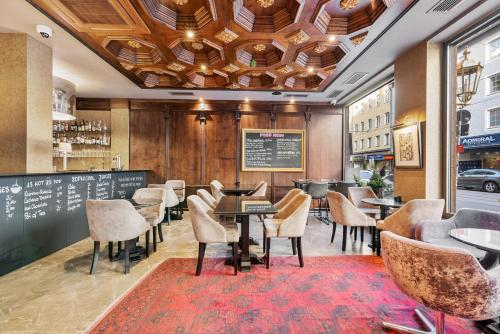 a restaurant with tables and chairs and a chalkboard at KING's Hotel First in Munich