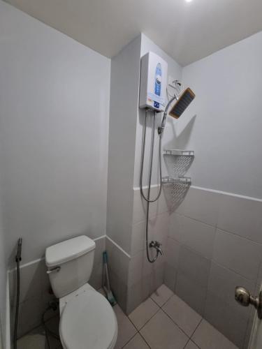 a white bathroom with a toilet and a shower at Macks Awesome Place 204 NetflixFastWifi in Manila