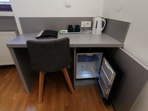 Rooms Sincere 1830 في ليوبليانا: مكتب عليه كرسي وجهاز كمبيوتر محمول