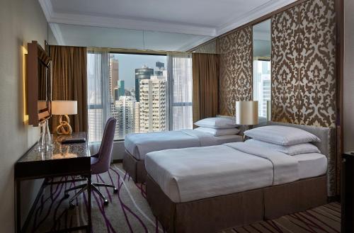 香港的住宿－香港灣仔帝盛飯店，酒店客房设有两张床、一张书桌和一个窗户。