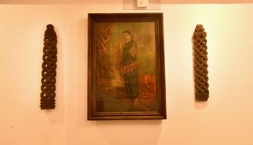 a painting of a man on a wall with two mirrors at Dj Villa in Puducherry