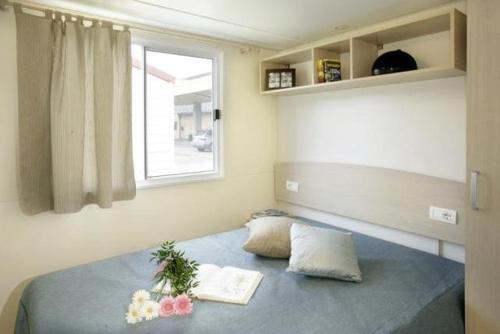 Seaside Tkon Mobile Homes في تكون: غرفة نوم بها سرير عليه زهور