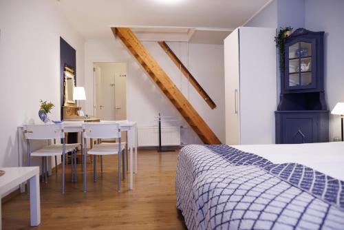 a bedroom with a bed and a table and chairs at Mariafarm in Zevenbergen