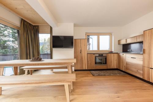 a kitchen with wooden cabinets and a wooden table at Pension Gulla - Ferienhaus Appartements B&B in Neustift im Stubaital