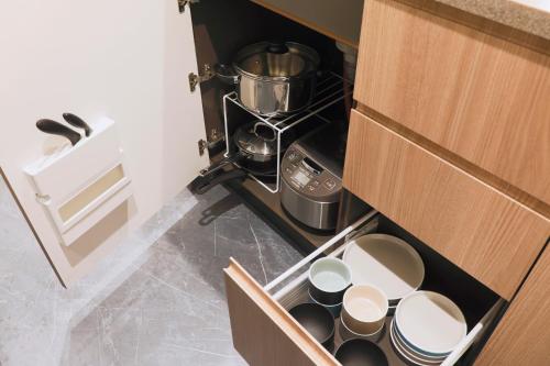 eine Schublade in einer Küche mit Tassen und Herd in der Unterkunft stayme THE HOTEL Ueno in Tokio