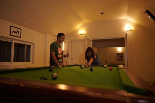 a man and a woman playing a game of pool at The Fog Munnar (Resort & Spa) in Munnar