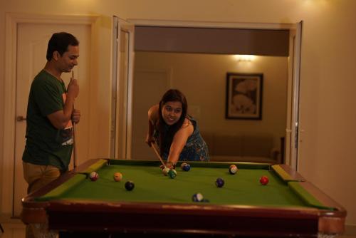 a man and a woman playing a game of pool at The Fog Munnar (Resort & Spa) in Munnar