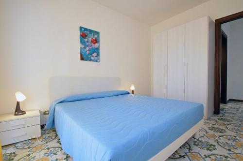 Schlafzimmer mit einem Bett mit blauer Tagesdecke in der Unterkunft Residence Le Magnolie in Martinsicuro