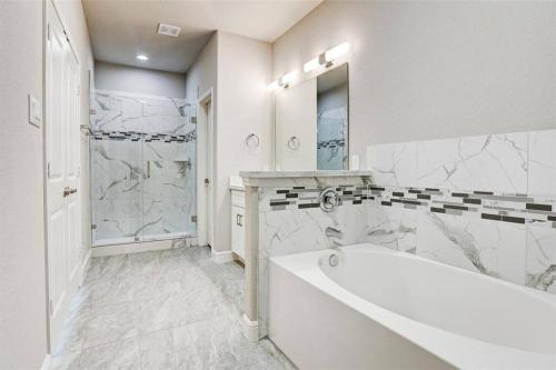 a white bathroom with a tub and a shower at Cozy Luxury Houston 3Bed 2Bath near NRG and Med Center in Houston