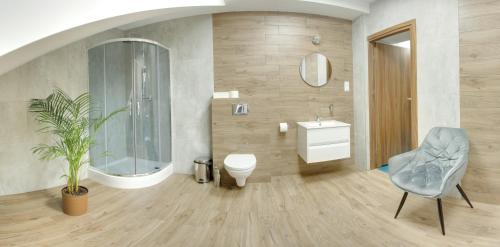 a bathroom with a toilet and a sink and a chair at Celestynka in Rymanów-Zdrój